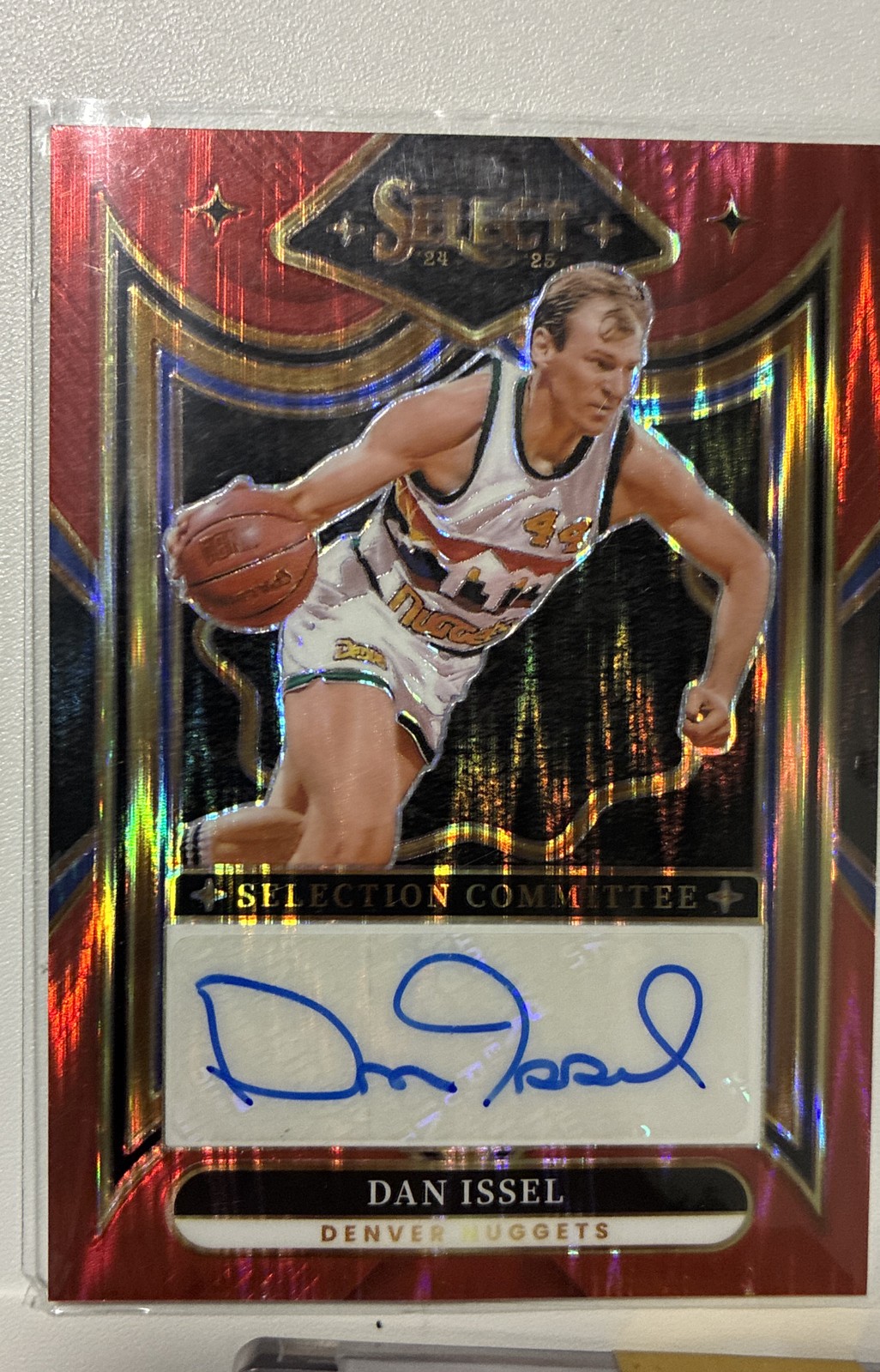 2024-25 Panini Select – Signatures Dan Issel #SC-ISS Red Flash Prizm /99 (AU)